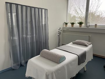Terapeutické lehátko u okna se závěsem